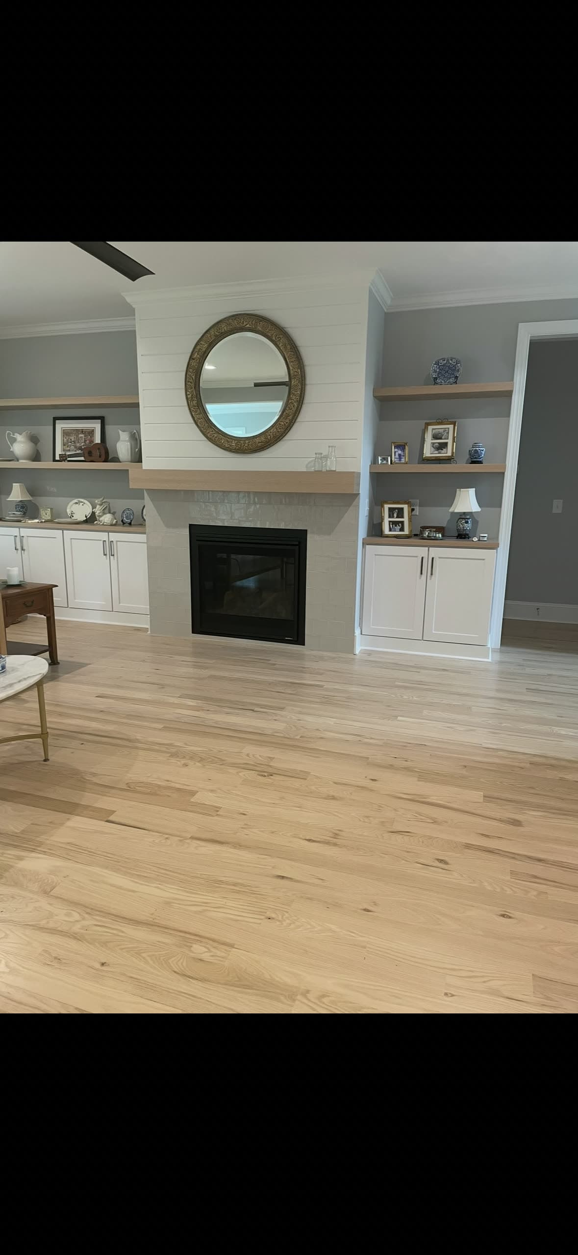 Wide-plank light oak floor in a living room with shiplap fireplace — a recent Gladden project